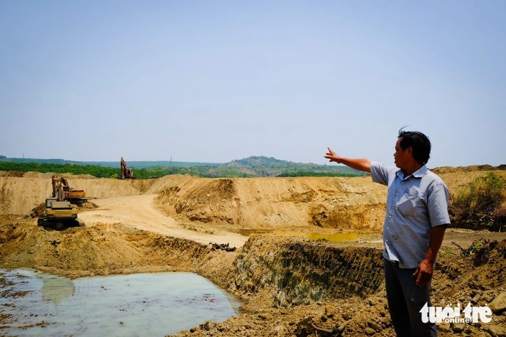 Nông dân Hoàng Văn Chọn bên cái ao rộng hơn 1ha đang đào làm nơi chứa 140.000m3 nước - Ảnh: TẤN LỰC