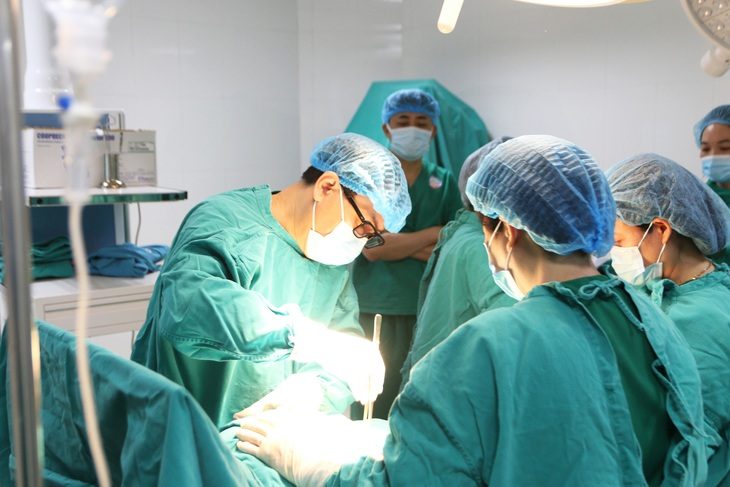 PGS.TS Vũ Văn Tâm, giám đốc Bệnh viện Phụ sản Hải Phòng (đeo kính), trực tiếp thực hiện một ca phẫu thuật tại Bệnh viện Sản nhi Lào Cai để đội ngũ y bác sĩ khác thị phạm - Ảnh: TRẦN LỰC